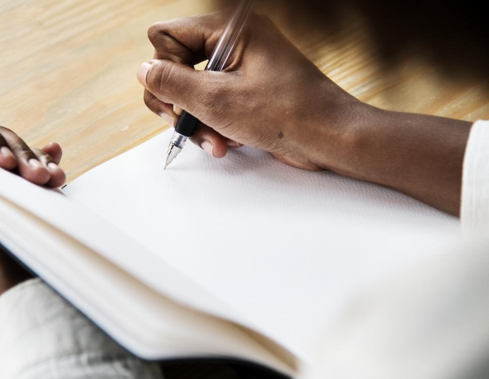 close-up-of-hand-writing-on-a-notebook